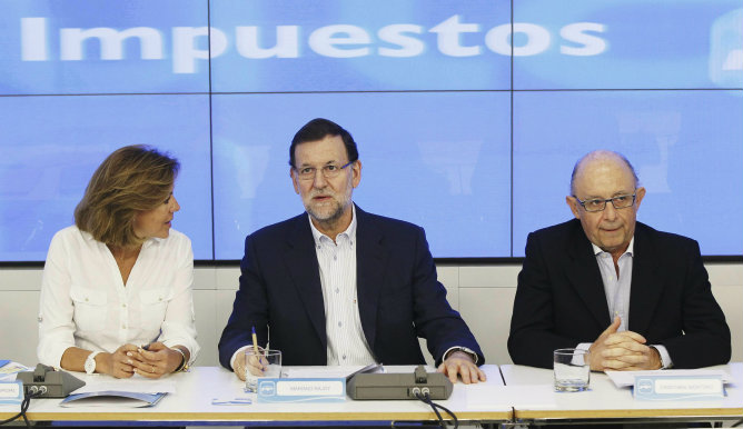 Mariano Rajoy junto al ministro de Hacienda, Cristóbal Montoro, y a la secretaria general del PP, María Dolores de Cospedal, al inicio de la reunión que ha tenido lugar este sábado en la sede nacional del partido