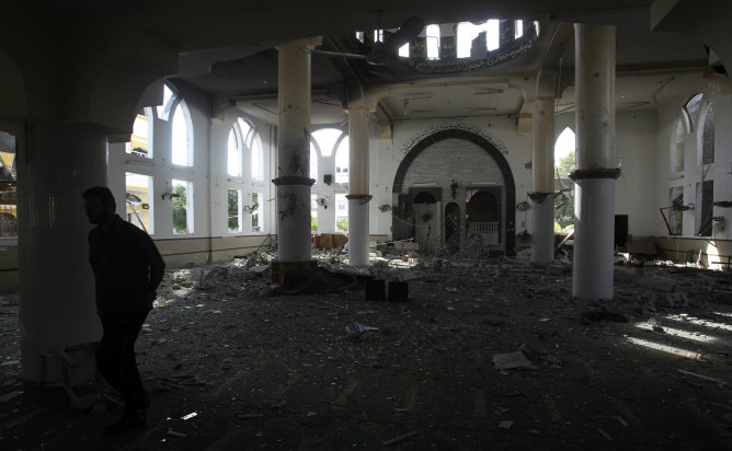 Un palestino camina en una mezquita dañada que fue alcanzada por un ataque aéreo israelí