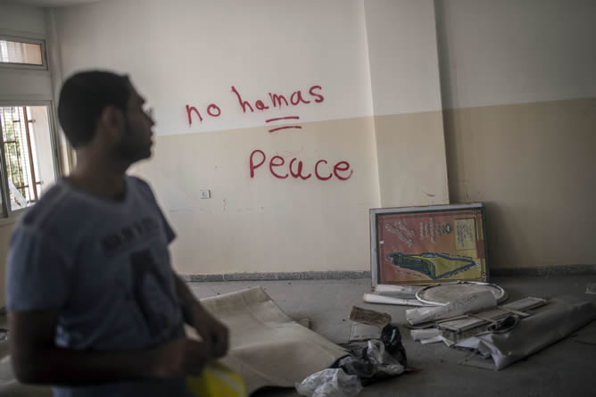 Un palestino observa un escrito en una pared obra de soldados israelíes en el que se lee: "No Hamás = paz", en una pizarra de un instituto femenino que fue usado como cuartel para tropas israelíes durante su ofensiva en Gaza