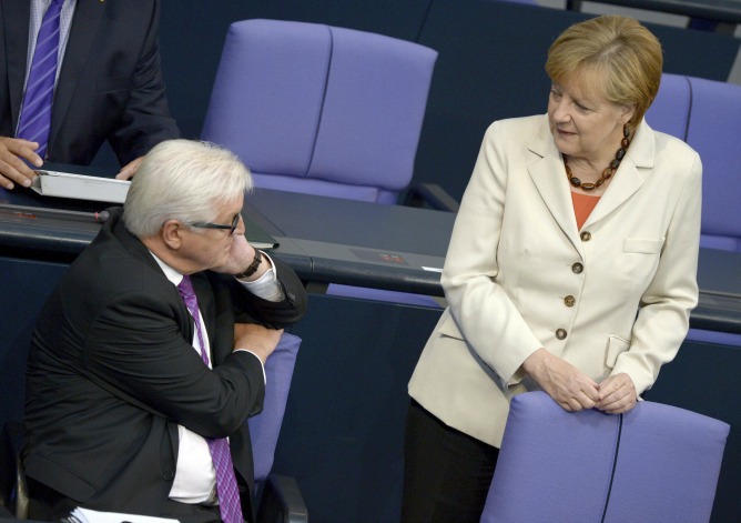 El ministro de Asuntos Exteriores alemán, Frank-Walter Steinmeier, y la canciller alemana, Angela Merkel, conversan durante una sesión en el Bundestag.