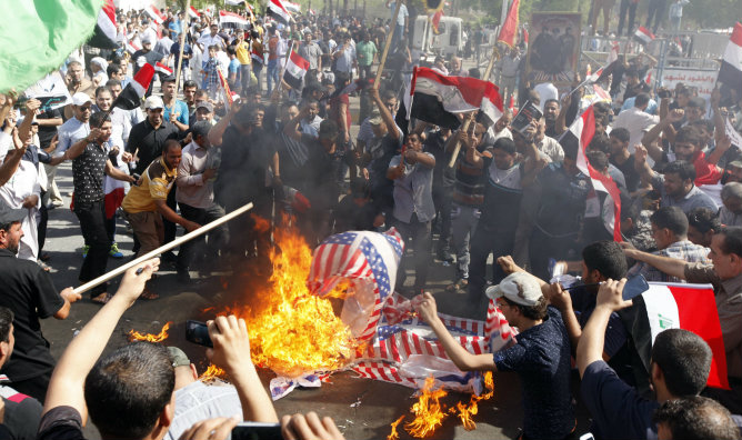 Seguidores del Estado Islámico queman banderas estadounidenses durante una protesta