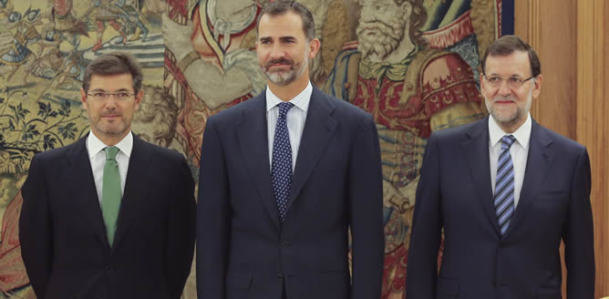 El rey posa junto al nuevo ministro de Justicia, Rafael Catalá (i), y el presidente del Gobierno, Mariano Rajoy (d), durante el acto celebrado en el Palacio de la Zarzuela en el que el nuevo titular de Justicia ha jurado su cargo