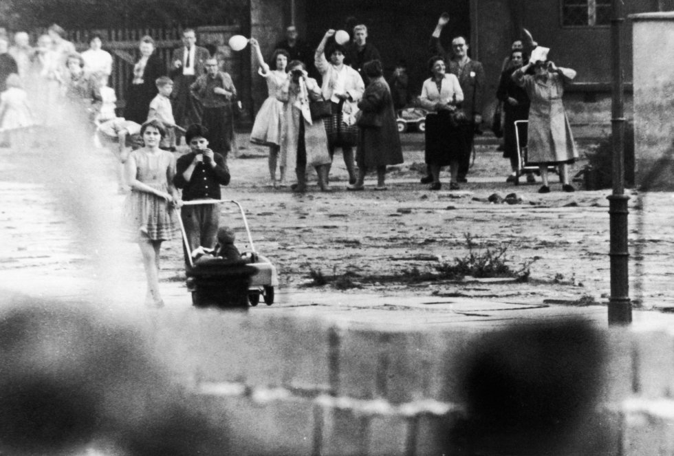 Familias y amigos que una vez fueron vecinos, se saludan de un lado a otro del muro que les divide. Imagen tomada en 1961. Familias y amigos que una vez fueron vecinos, se saludan de un lado a otro del muro que les divide. Imagen tomada en 1961.