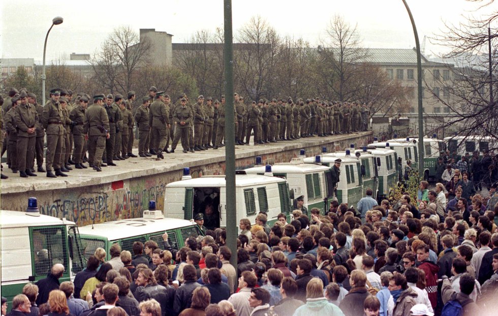 Cientos de guardias fronterizos del Este Berlín situados sobre el muro en la Puerta de Brandenburgo se enfrentan a los ciudadanos de Berlín occidental. Imagen de archivo tomada el 11 de noviembre de 1989. Cientos de guardias fronterizos del Este Berlín situados sobre el muro en la Puerta de Brandenburgo se enfrentan a los ciudadanos de Berlín occidental. Imagen de archivo tomada el 11 de noviembre de 1989.