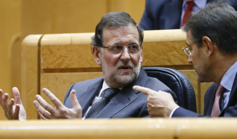El presidente del Gobierno, Mariano Rajoy, conversa con el ministro de Justicia, Rafael Catalá.