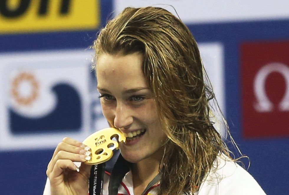 La nadadora Mireia Belmonte García celebra en el podio la medalla de oro y el nuevo récord mundial conseguido en la final de los 200 metros mariposa durante la 12º edición de los Mundiales de natación de piscina corta en el Hamad Aquatic Centre en Doha, Catar