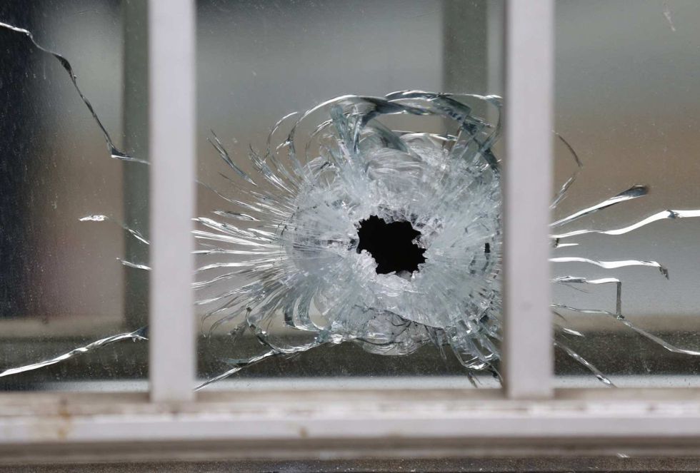 Una ventana rota después del tiroteo que se ha producido en las oficinas de la revista satírica