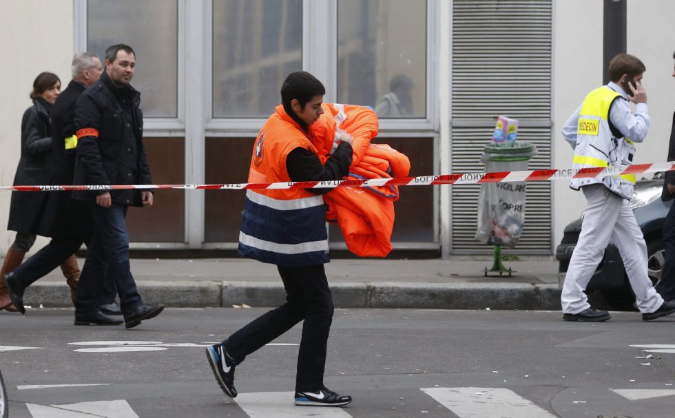 Un trabajador sanitario pasa cerca de las oficinas del semanario satírico francés 'Charlie Hebdo' tras el ataque contra la redacción