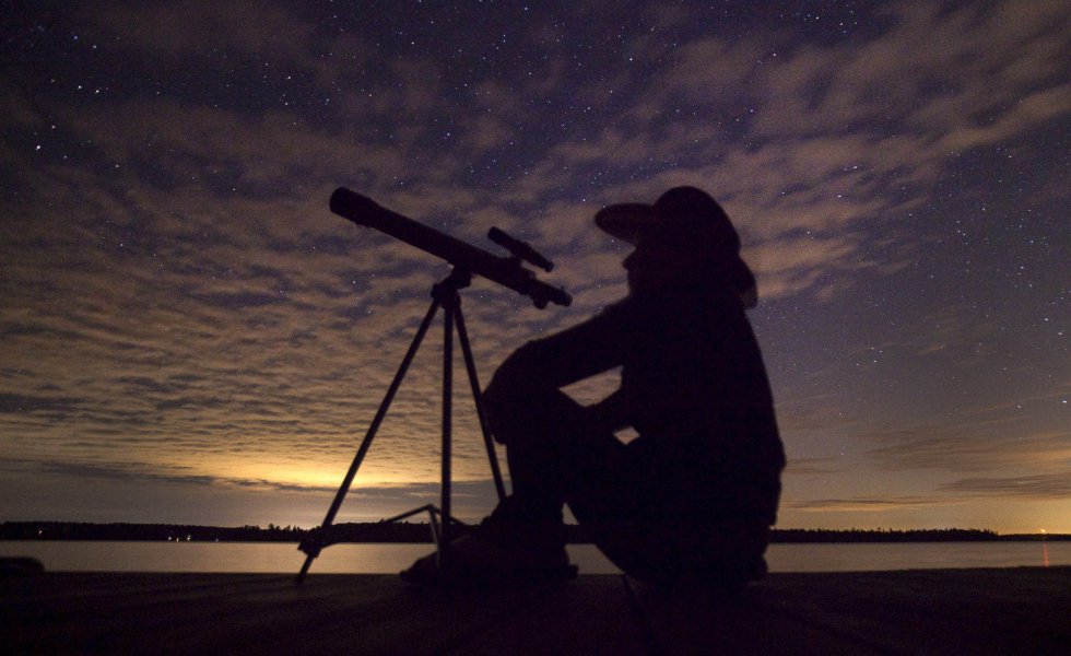 Una persona observa con su telescopio el cielo. Una persona observa con su telescopio el cielo.