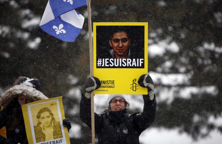 CBX11 OTTAWA (CANADÁ), 29/10/2015.- Fotografía de archivo fechada el 29 de enero de 2015 que muestra a una mujer que sostiene una pancarta con la imagen del bloguero saudí Raif Badawi durante una marcha hacia el Parlamento en Ottawa, Canadá. Badawi resultó hoy, 29 de octubre de 2015, ganador del premio Sájarov a la Libertad de Conciencia que concede cada año el Parlamento Europeo (PE). Badawi, fundador del foro en internet Red Liberal Saudí, fue condenado en septiembre de 2014 a diez años de cárcel y a recibir mil latigazos por "insultar al Islam" y criticar a la "policía de la moral" saudí en su blog. EFE/COLE BURSTON