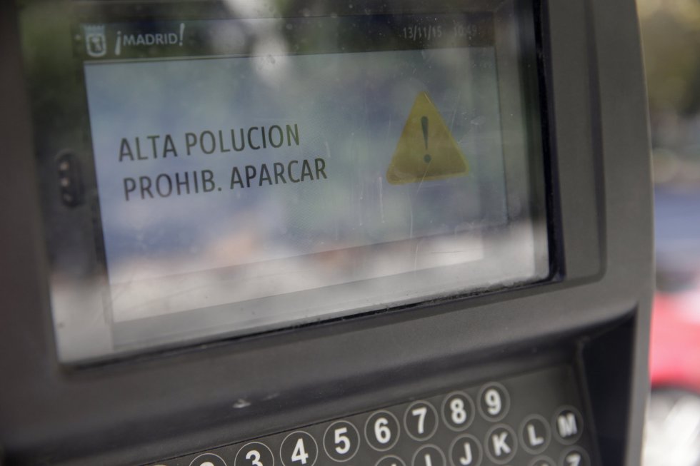 Detalle del cartel con el mensaje "Alta polución. Prohibido aparcar" instalado en lun parquímetro de la plaza de la Lealtad, en Madrid.