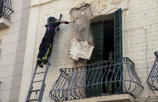 Un bombero derriba parte de la decoración de un edificio de Melilla, dañado tras el terremoto