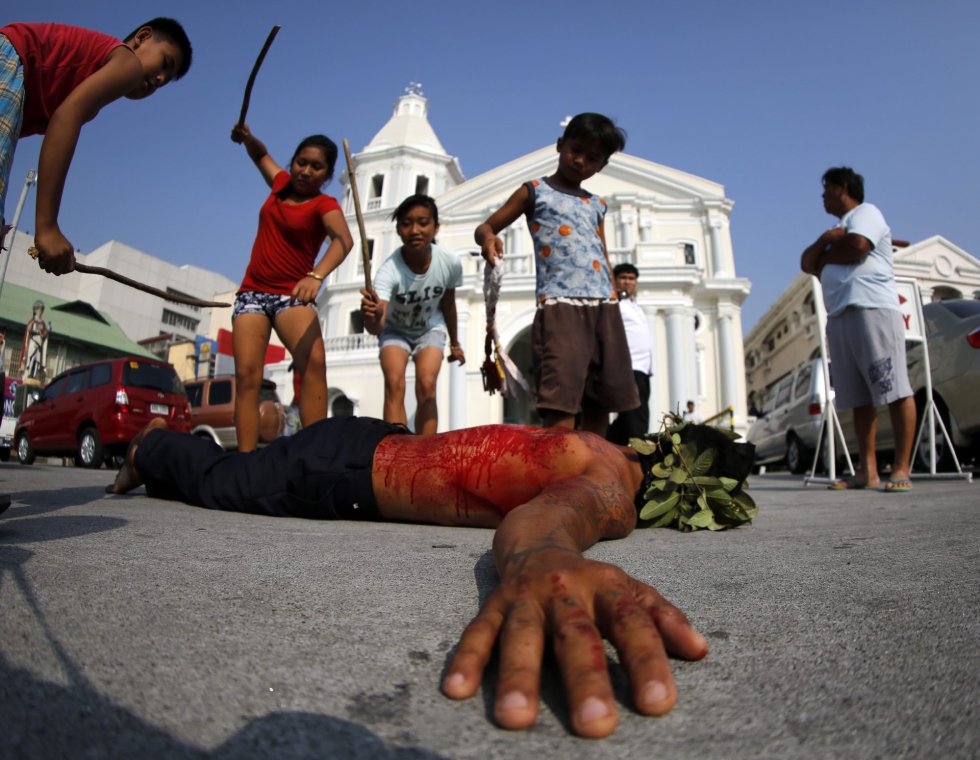 Niños pegan a un penitente flagelado en San Pedro Cutud en San Fernando al norte de Manila (Filipinas). Niños pegan a un penitente flagelado en San Pedro Cutud en San Fernando al norte de Manila (Filipinas).