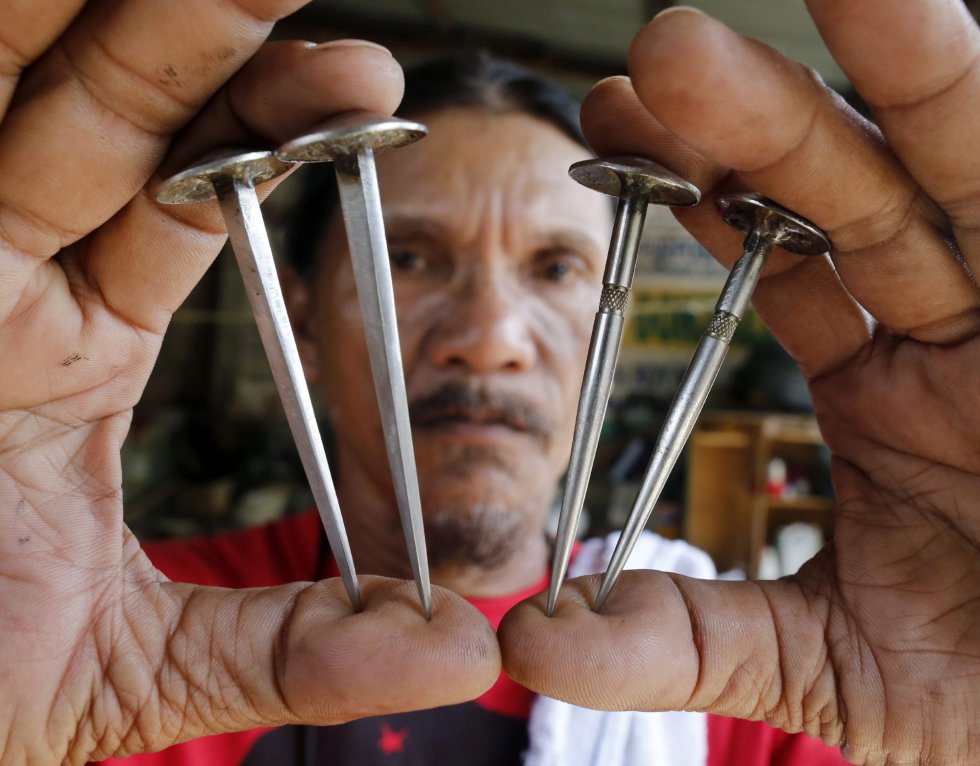 El penitente Ruben Enaje muestra los cuatro clavos que serán utilizados para crucificarle otra vez, como cada año desde hace 30, en San Pedro Cutud en San Fernando al norte de Manila (Filipinas). El penitente Ruben Enaje muestra los cuatro clavos que serán utilizados para crucificarle otra vez, como cada año desde hace 30, en San Pedro Cutud en San Fernando al norte de Manila (Filipinas).