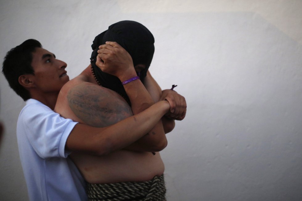 Un hombre ayuda a otro a preparar los músculos antes de una procesión en Taxco, en el estado mexicano de Guerrero. Un hombre ayuda a otro a preparar los músculos antes de una procesión en Taxco, en el estado mexicano de Guerrero.