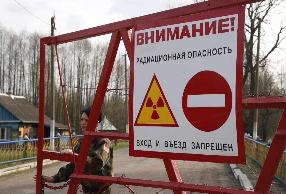 Una guardia bielorrusa abre la puerta de control de la Reserva Radioecológica Estatal dentro de la zona de exclusión a 30 kilómetros del reactor nuclear de Chernóbil, a algo más de 390 kilómetros de Minsk, Bielorrusia. Una guardia bielorrusa abre la puerta de control de la Reserva Radioecológica Estatal dentro de la zona de exclusión a 30 kilómetros del reactor nuclear de Chernóbil, a algo más de 390 kilómetros de Minsk, Bielorrusia.