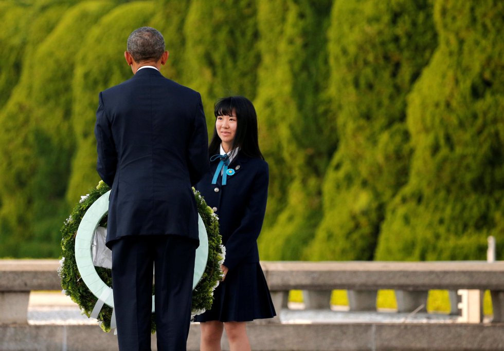 Obama recoge una corona de flores de mano de una estudiante. Obama recoge una corona de flores de mano de una estudiante.