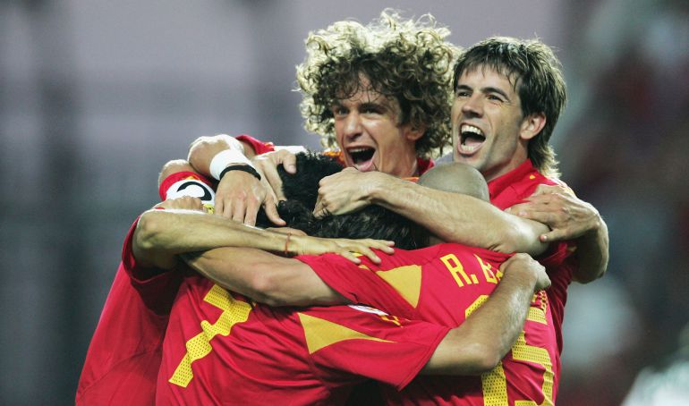 Puyol y Albelda se abrazan con más jugadores durante un partido de la Eurocopa 2004