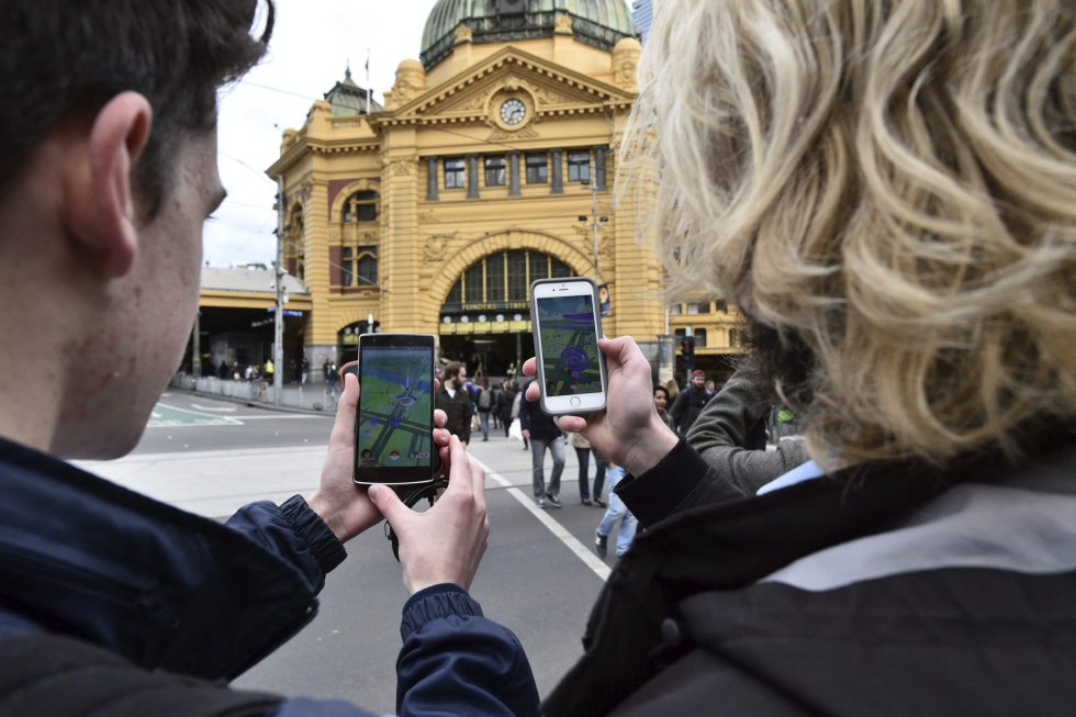 Dos estudiantes prueban el nuevo juego 'Pokémon Go' en su móvil en Melbourne (Australia).