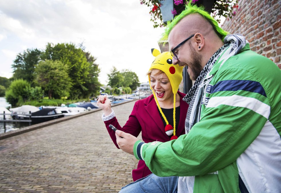 Dos personas juegan Pokemon Go en sus teléfonos móviles en Leerdam (Holanda).