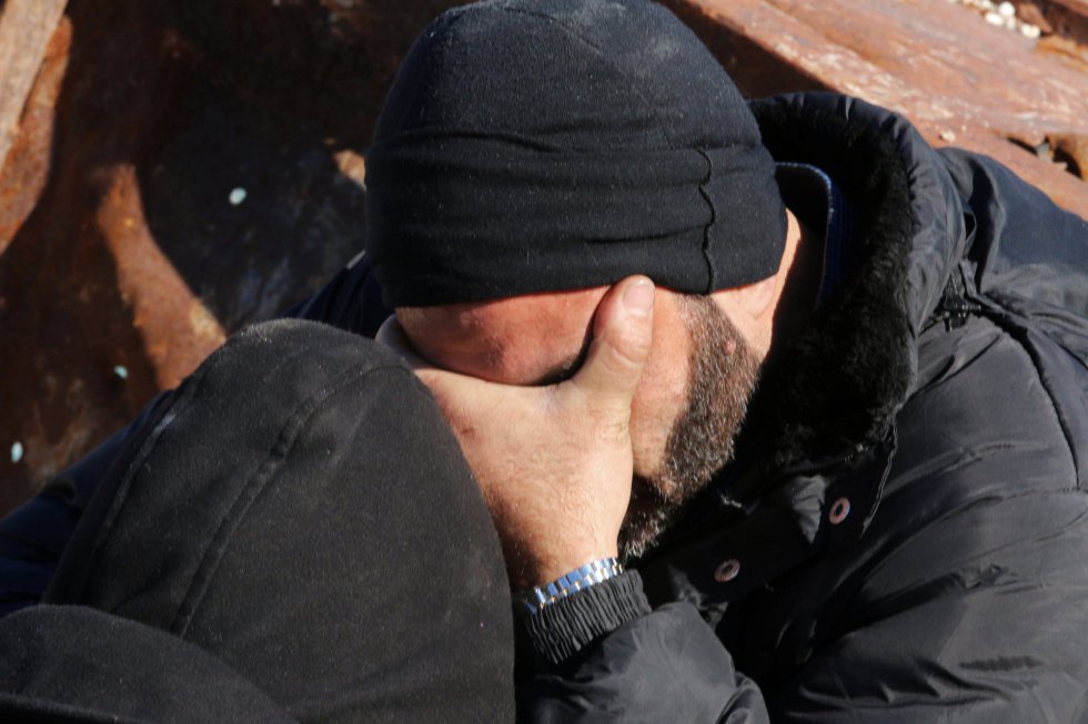 Un hombre espera junto a otros a ser evacuado. Un hombre espera junto a otros a ser evacuado.