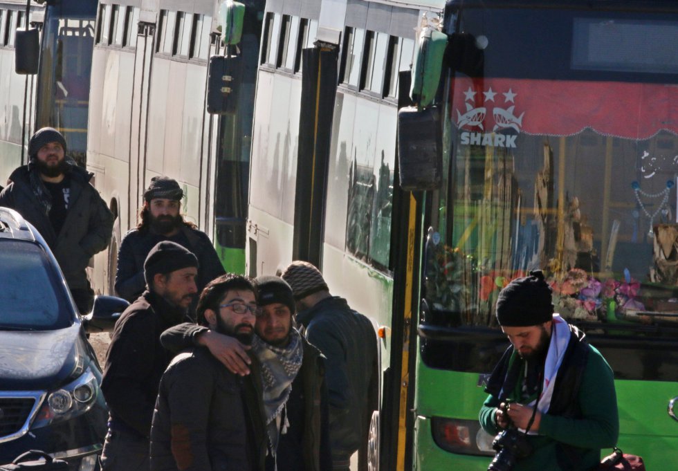 Un grupo de hombres se abraza a la espera de subir al autobús para ser evacuados.
Un grupo de hombres se abraza a la espera de subir al autobús para ser evacuados.