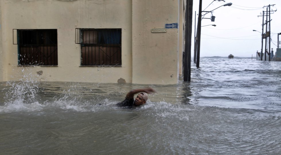 Un hombre nada por una calle inundada de la capital cubana. Un hombre nada por una calle inundada de la capital cubana.