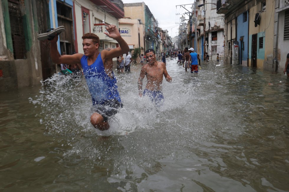Jóvenes corriendo a través de una de las calles inundadas en la Habana tras el paso del huracán Irma. Jóvenes corriendo a través de una de las calles inundadas en la Habana tras el paso del huracán Irma.