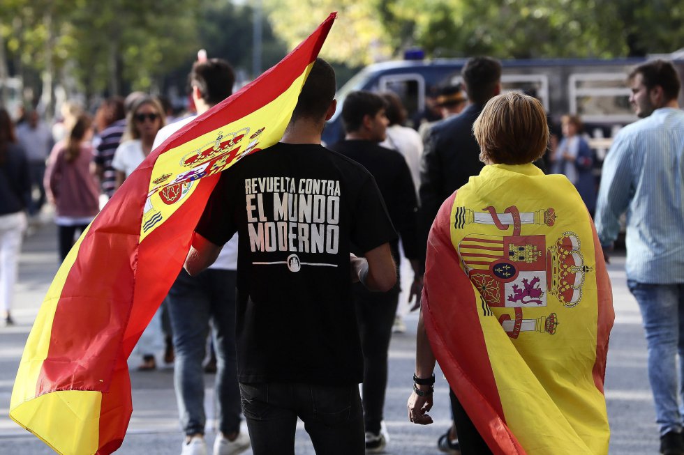 Dos personas portan la bandera española antes del inicio del desfile del Día de la Fiesta Nacional. Dos personas portan la bandera española antes del inicio del desfile del Día de la Fiesta Nacional.