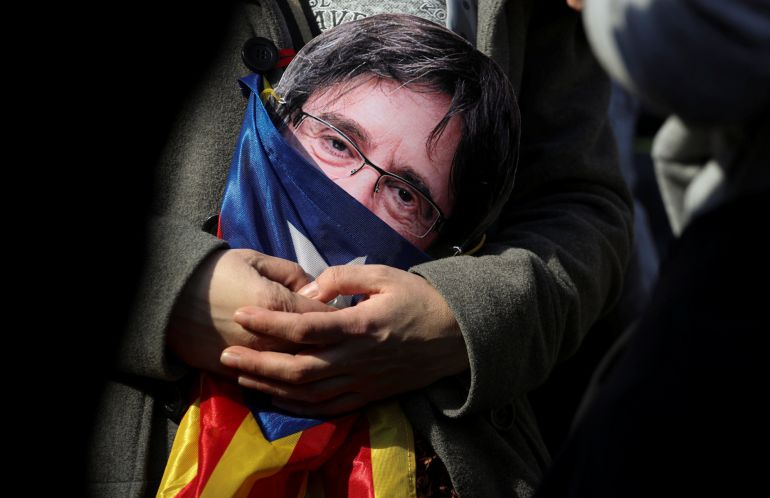 Un manifestante con una careta de Carles Puigdemont durante un acto en Barcelona