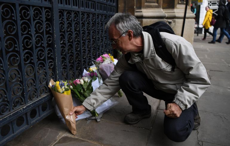 Un hombre deposita flores en la capilla de Gonville and Caius College en Cambridge (Reino Unido) como tributo al fallecido científico Stephen Hawking 