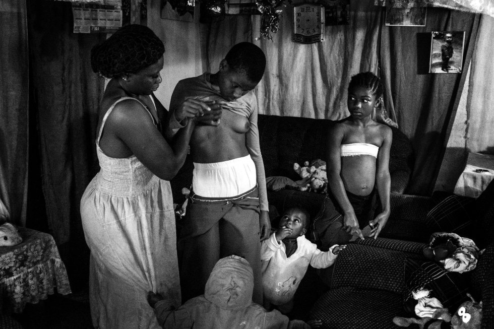 La fotógrafa Heba Khamis ha ganado el primer premio de la categoría 'Contemporary Issues' con esta foto de Veronica, de 28 años, mientras masajea el pecho de su hija de 10 años Michelle, en compañía de sus otras hijas en Bafoussam, Camerún, el 7 de noviembre de 2016. La fotógrafa Heba Khamis ha ganado el primer premio de la categoría 'Contemporary Issues' con esta foto de Veronica, de 28 años, mientras masajea el pecho de su hija de 10 años Michelle, en compañía de sus otras hijas en Bafoussam, Camerún, el 7 de noviembre de 2016.