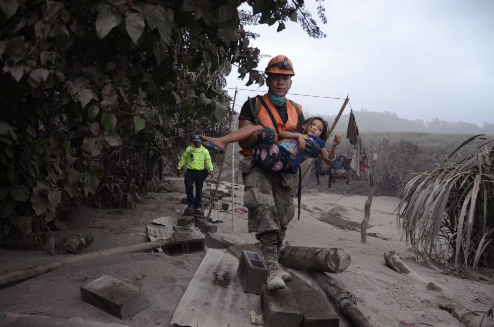 Un trabajador de los equipos de rescate de Guatemala ayuda a una niña en El Rodeo, Escuintla (Guatemala) tras la erupción del volcán de Fuego, que ha dejado al menos 25 muertos, 20 heridos y más de 1,7 millones de personas afectadas. Un trabajador de los equipos de rescate de Guatemala ayuda a una niña en El Rodeo, Escuintla (Guatemala) tras la erupción del volcán de Fuego, que ha dejado al menos 25 muertos, 20 heridos y más de 1,7 millones de personas afectadas.