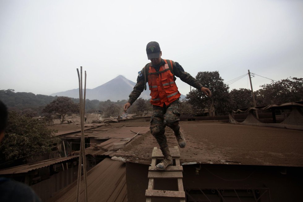 Un soldado corre por un deslizamiento de fluido del volcán de Fuego Un soldado corre por un deslizamiento de fluido del volcán de Fuego