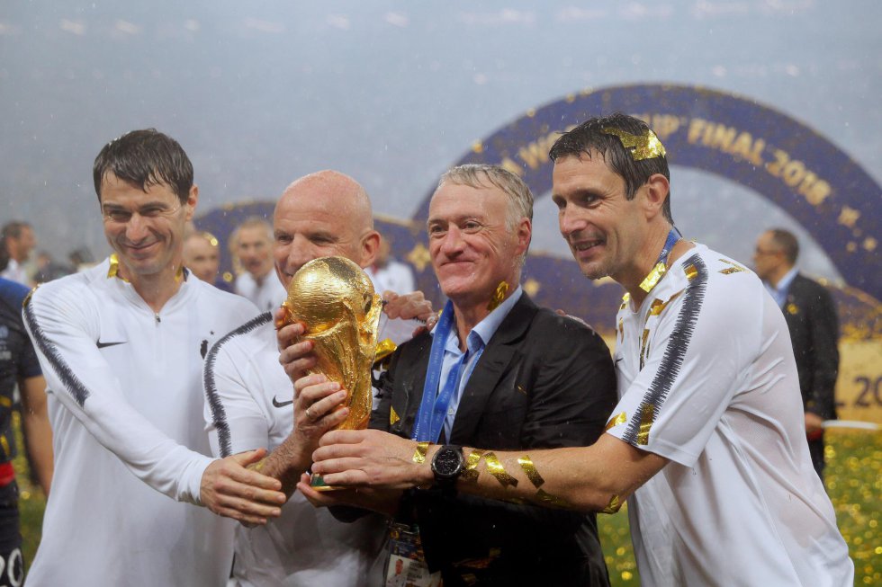 El técnico francés Didier Deschamps posa con el trofeo junto a su cuerpo técnico tras el partido Francia-Croacia.