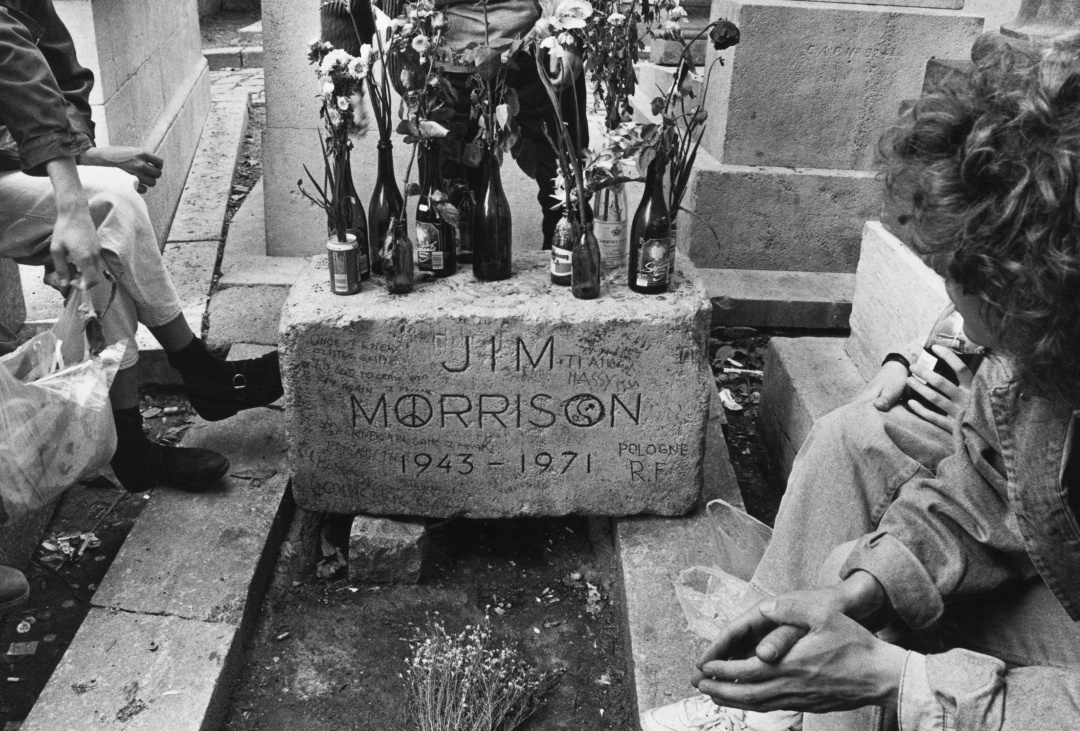 Un grupo de seguidores junto a la tumba de Jim Morrison en París