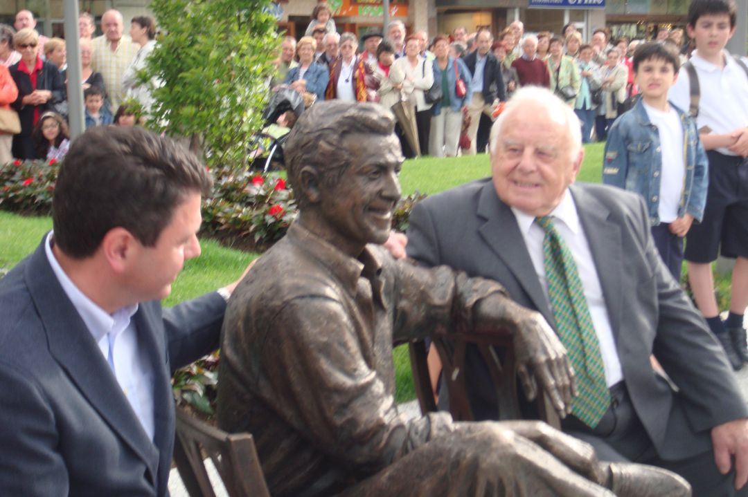 El alcalde y Patxi Lacan, sentados junto a la escultura de Luis Mariano. 