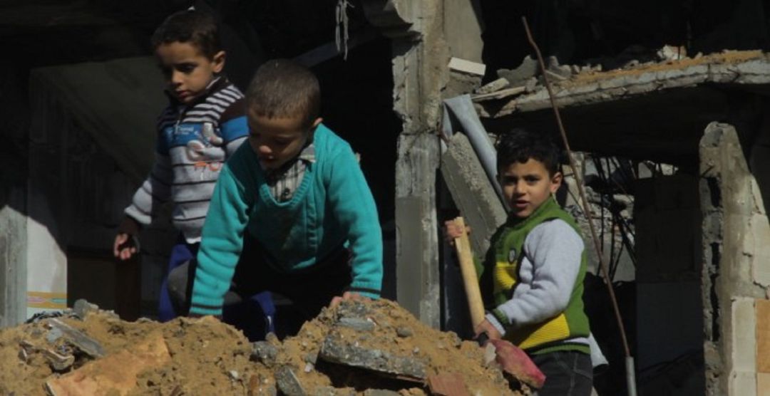 Fotograma del corto documental nominado a los Goya 'Gaza. Una mirada a los ojos de la barbarie' en el que varios niños juegan en una vivienda en ruinas