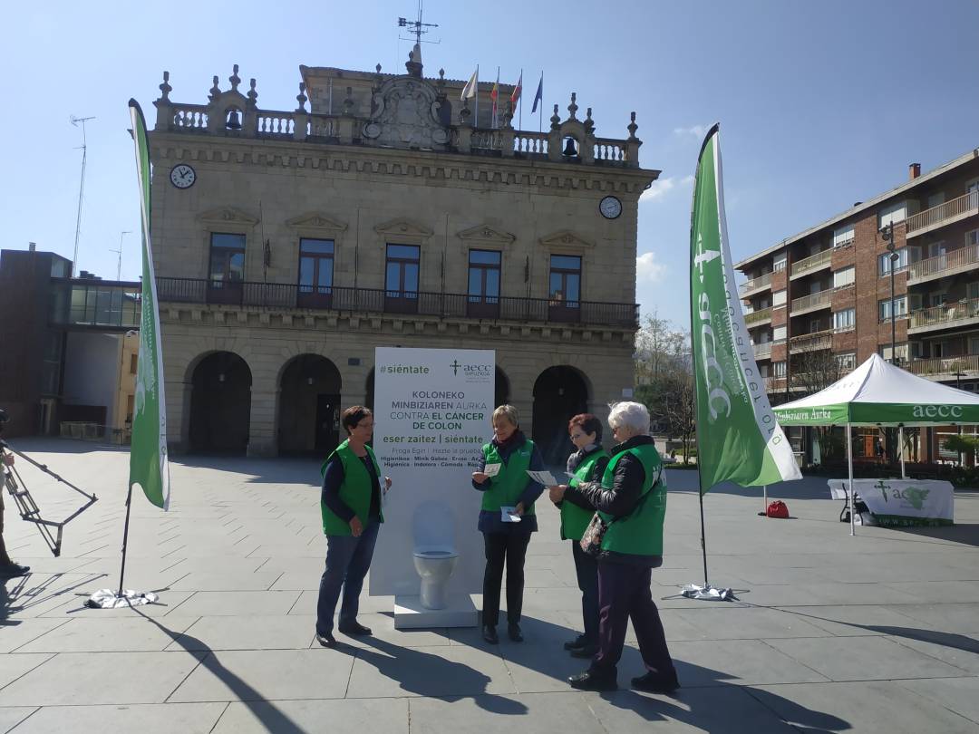 Voluntarias de la AECC en la plaza San Juan, en la que se ha colocado como gancho un retrete, para concienciar sobre la prevención del cáncer de colon.