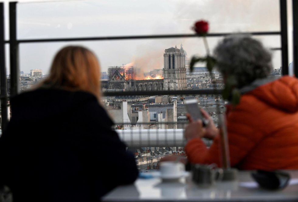 Personas observan un incendio en la catedral de Notre Dame este lunes en París, Francia. Personas observan un incendio en la catedral de Notre Dame este lunes en París, Francia.