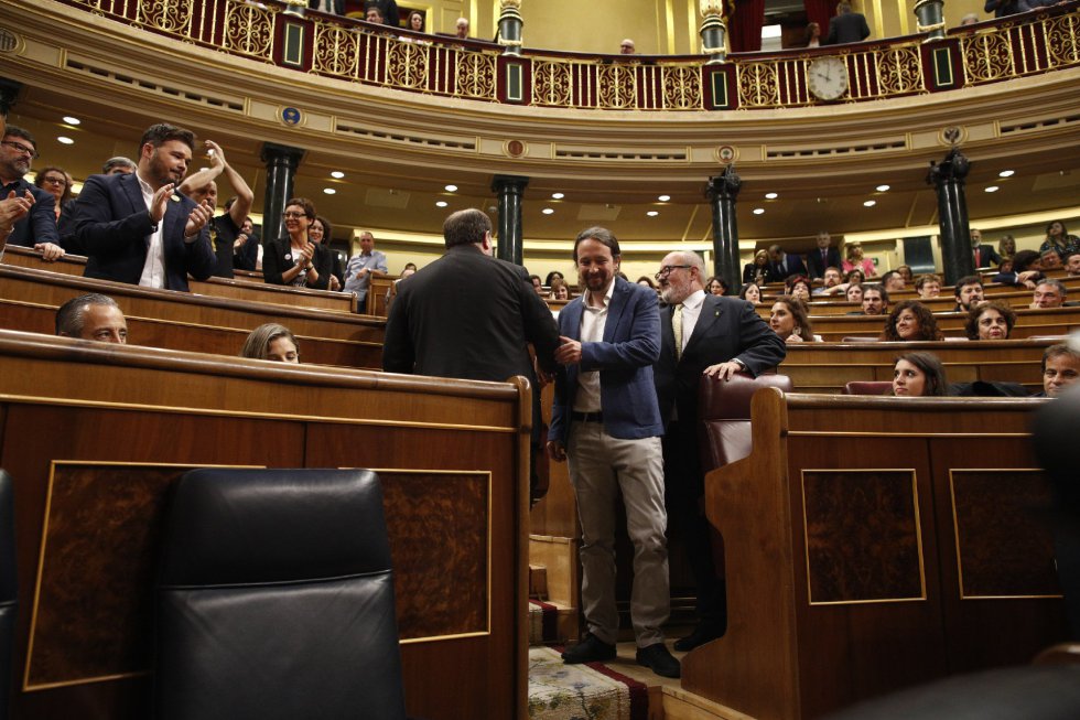 El portavoz de ERC en el Congreso de los Diputados, Gabriel Rufián (i), aplaude el saludo del secretario general de Podemos, Pablo Iglesias (d), Oriol Junqueras (c), en el Congreso