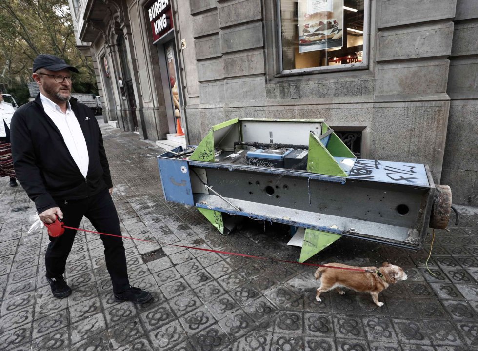 Un hombre pasea a su perro junto a una cabina arrancada Un hombre pasea a su perro junto a una cabina arrancada