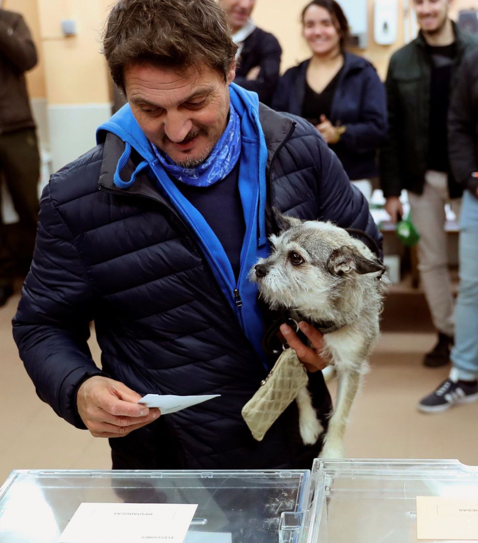 Un elector acompañado de su mascota deposita su voto en la urna Un elector acompañado de su mascota deposita su voto en la urna