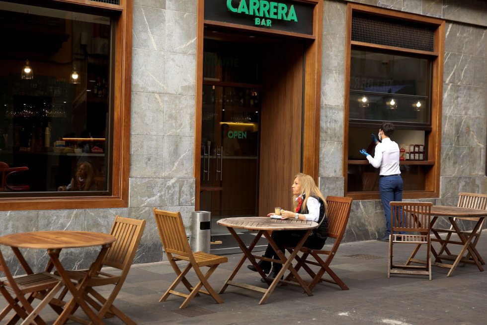 Una mujer desayuna en una terraza de un bar de La Laguna, en Tenerife, donde este lunes comenzó la Fase 1 de la desescalada y por ello está autorizado la apertura del pequeño comercio con restricción de aforo. Una mujer desayuna en una terraza de un bar de La Laguna, en Tenerife, donde este lunes comenzó la Fase 1 de la desescalada y por ello está autorizado la apertura del pequeño comercio con restricción de aforo.
