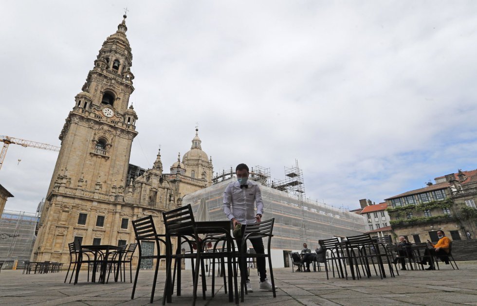 Un camarero monta la terraza de la plaza de A Quintana, ante la catedral, en el primer día de la fase 1 de la desescalada del confinamiento por el Civid 19, esta mañana en Santiago de Compostela. Un camarero monta la terraza de la plaza de A Quintana, ante la catedral, en el primer día de la fase 1 de la desescalada del confinamiento por el Civid 19, esta mañana en Santiago de Compostela.