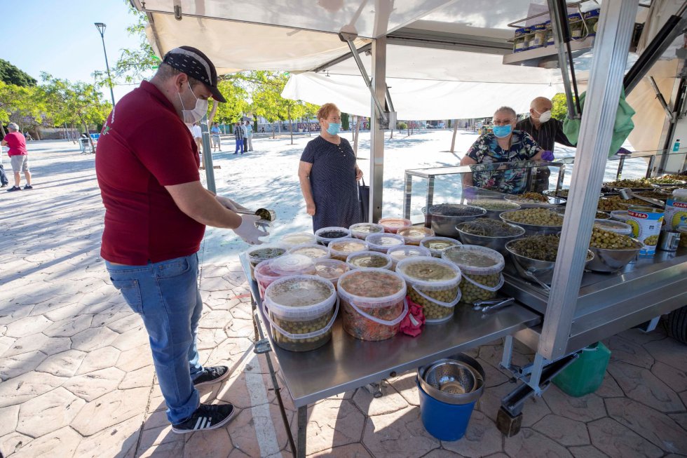 Varias personas compran en un puesto de encurtidos del mercadillo semanal del Barrio Peral de Cartagena, este lunes, primer día de la fase 1 de desescalamiento por la pandemia. Varias personas compran en un puesto de encurtidos del mercadillo semanal del Barrio Peral de Cartagena, este lunes, primer día de la fase 1 de desescalamiento por la pandemia.
