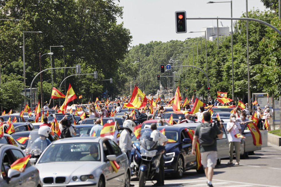 Coches y motos, con pancartas y banderas de España, circulan por las calles de la capital en la manifestación de Vox para pedir la dimisión del Gobierno de Pedro Sánchez por su gestión durante la pandemia del COVID-19. Coches y motos, con pancartas y banderas de España, circulan por las calles de la capital en la manifestación de Vox para pedir la dimisión del Gobierno de Pedro Sánchez por su gestión durante la pandemia del COVID-19.