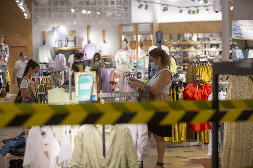 Algunas personas miran ropa en una tienda del centro comercial de Nervión durante el primer día de apertura de los centros comerciales al inicio de la Fase 2 del plan de desecalada en la capital andaluza. Algunas personas miran ropa en una tienda del centro comercial de Nervión durante el primer día de apertura de los centros comerciales al inicio de la Fase 2 del plan de desecalada en la capital andaluza.
