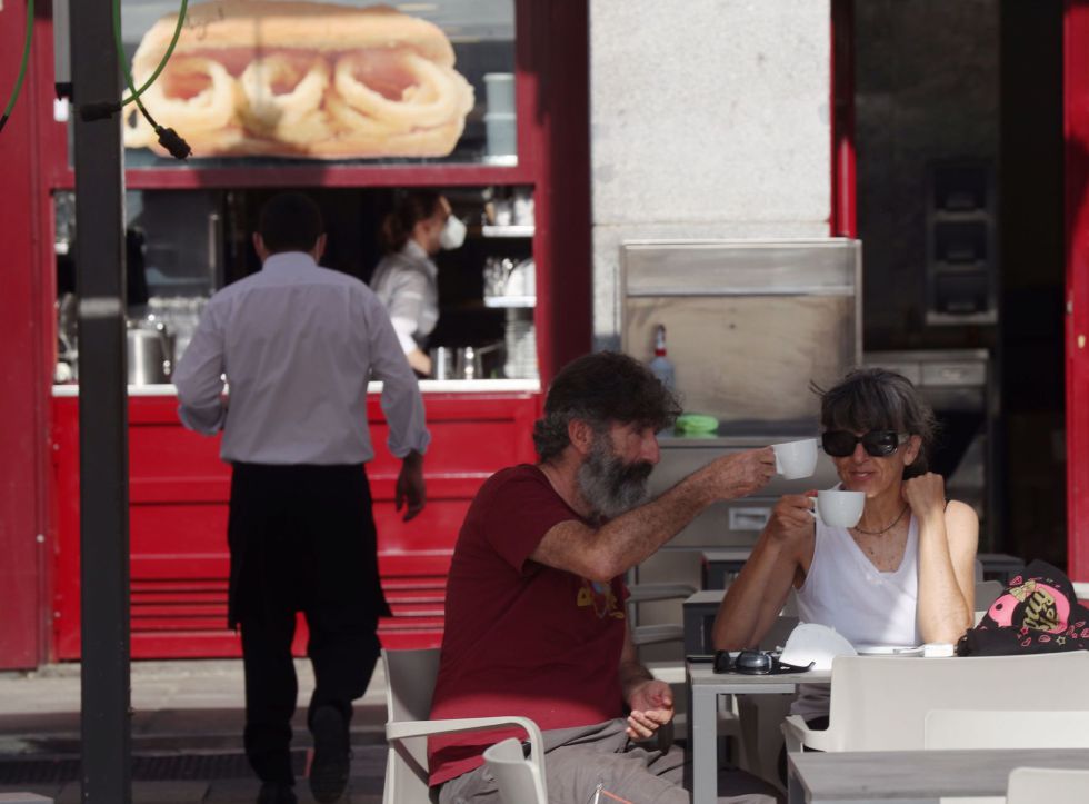 Dos personas disfrutan del desayuno en la terraza de un bar de la Plaza Mayor en Madrid este lunes. Dos personas disfrutan del desayuno en la terraza de un bar de la Plaza Mayor en Madrid este lunes.