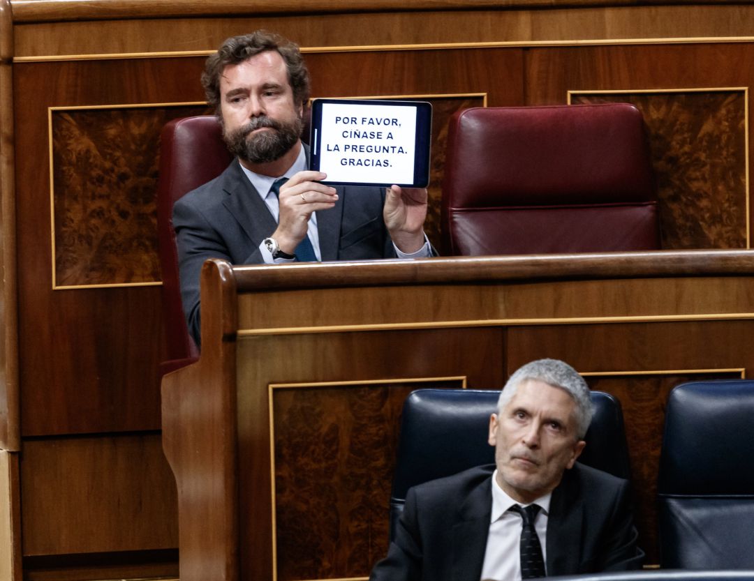 El diputado de VOX Iván Espinosa de los Monteros sostiene un cartel en el que pide ceñirse a las preguntas que se realizan durante la sesión de control al Gobierno, en presencia del ministro del Interior, Fernando Grande-Marlaska